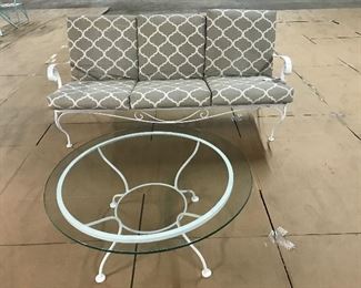 Woodard couch with cushions, round glass top table.