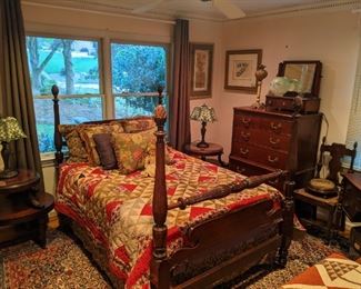 1930's mahogany 4-poster bed (pineapple finials) with antique hand-made quilt, pair of 1930's mahogany two-tiered bedside table, w/tooled leather top, glass covers,  pair of vintage Tiffany style stained glass table lamps, vintage 5-drawer mahogany chest, by Kindel Furniture Co., (Grand Rapids, MI), 1920's mahogany shaving stand with tilt mirror and three drawers, electrified gas table lamp,  1920's 4-drawer mahogany desk, w/matching chair, all atop a hand-woven Persian Bidjar rug.