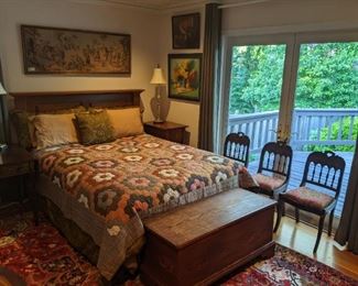 Queen size wormy pine hand-made headboard, with antique quilt, antique pine blanket chest, set/3 nicely upholstered side chairs, mahogany Pembroke side table with pencil inlay, custom made Shaker style single-drawer side table, vintage framed tapestry above bed, all atop a vintage, hand-woven Persian Heriz rug, measuring 8' 4" x 10' 3".