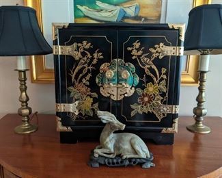 Pair of vintage brass candlestick lamps, vintage Asian black lacquer jewelry chest and carved soapstone donkey on custom wooden stand. 