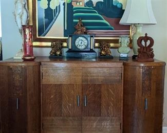 Sweet Art Deco oak chest, purchased from Turnage Place Antiques in 1983, marble mantle clock, pair of Asian foo dogs, soapstone Asian vase on stand, vintage terra cotta roof finial, cranberry/gold glass Art deco vase, nicely framed MCM original oil on canvas. 