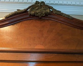 Close-up  of the sunrise wood inlay top detail and bronze mount.