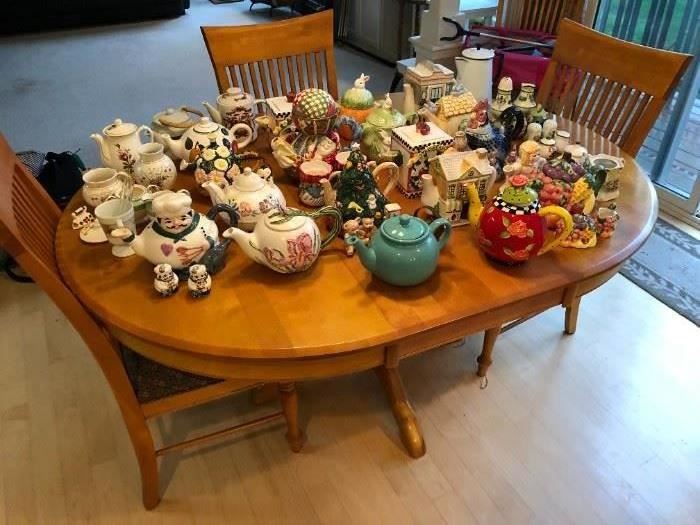 Dining table with one leaf and six chairs; large collection of teapots.