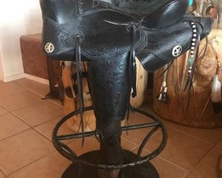 Four black leather bar stools.  Each one is different and unique.  They would be great and very fun to have around a table too!  What a great conversation piece!!