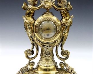 A turn of century Lenzkirch Bronze table clock with Bacchanalian design.  14-day time only movement with platform escapement, Silvered dial and Arabic numerals, serial # 1 Million 689866.  Cast Bronze case with a female bust and cherubs, on a fluted pedestal with scrolled supports and foliate detail on a shaped base with short feet.  Polished case with minor wear, polish residue, running when cataloged.  16" high.  ESTIMATE $1,000-1,500