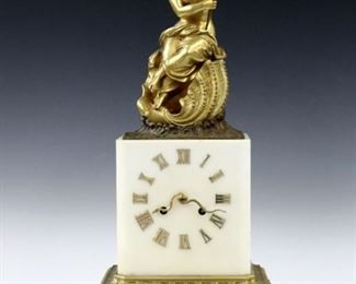 A late 19th century French Bronze table clock by Vincenti & Cie retailed by Robein, Paris.  8-day time and strike movement with silk thread suspension, marble dial with serpent hands and applied Roman numerals.  White Marble case with gilded bronze figure of Amphitrite seated in a shell with waves beneath on a chamfered base with gilded Bronze molding and feet.  Only slight wear, replaced horn, running when cataloged.  18 3/4" high.  ESTIMATE $1,000-1,500 