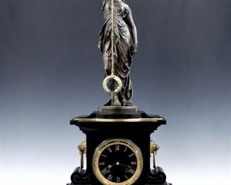 A 19th century French Mystery clock by André Romain Guilmet, Paris.  14-day spring driven time and strike movement with Black Slate dial and inlaid Roman numerals, cast Bronze bezel, adjustable Brass and Steel pendulum with gilded Bronze mounts and Crystal bob,  rear plate with "G L T" trademark, serial #208.  Black Slate case surmounted by a Bronze classically-draped figure of a Greek Goddess which suspends the pendulum, with gilded moldings, Lion's mask side handles and a shaped molded base supported by paw feet.  Minor surface wear, a few tiny edge flakes to the slate, running when cataloged.  31" high overall.  ESTIMATE $6,000-8,000
