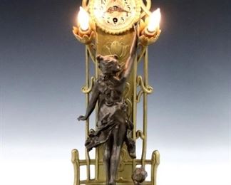 An early 20th century Lenzkirch Art Nouveau table clock with lights.  8-day time only movement with Silvered dial and Arabic numerals, serial # 1 Million 448320.  Cast Spelter case with floral design, patinated figures and two small bulbs.  Older Gold painted finish with minor wear, running when cataloged, lights up.  20 1/4" high.  ESTIMATE $1,000-1,500