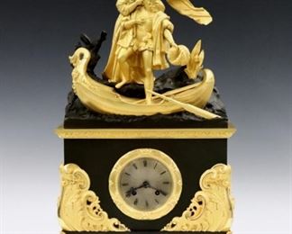 An early 19th century French Empire Period Bronze mantle clock.  8-day time and strike movement with Silvered dial and Roman numerals, serial #112394.  Two color Bronze case with a Queen Isabella and Columbus at the waters edge, lower case with gilded bezel and foliate scrolls on stylized Dolphin feet.  Patina in remarkable condition with only slight wear, minor wear to the dial, running when cataloged.  20 1/2" high.  ESTIMATE $1,500-2,500