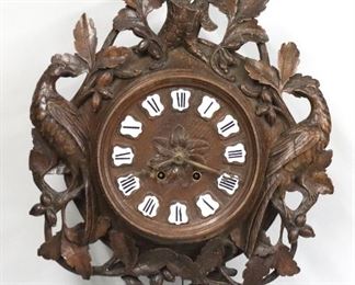A late 19th century German Cuckoo clock with exposed oversize songbird at crown.  30 hour spring driven time and strike movement with carved wooden dial and Roman numerals on porcelain plaques, painted songbird at crest.  Oak case with upper songbird over a reticulated body with carved oak leaves and Pheasants.  Older finish with wear and minor damage, restored songbird, running when cataloged.  Approx 24 1/2" high.   ESTIMATE $1,000-1,500