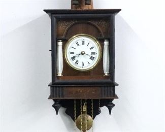 A turn of the 20th century German Black Forest wall clock with "Dumpling Eater" automaton.  30 hour time and strike movement with Gong strike, porcelain dial with Roman numerals.  Pine case with painted detail, upper carved wooden figure over a single door with hand painted frieze and porcelain pilasters above a shaped drop.  Original finish with some wear, restored figure, running and functioning when cataloged. 26" high plus weight drop. ESTIMATE $1,000-2,000