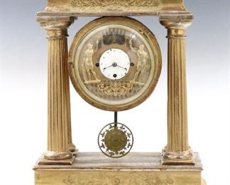 A 19th century Austrian Portico clock with double Jacquemart animation.  30 hour time and strike movement with quarter hour striking on two bells, engraved gilded Brass dial with porcelain center and Arabic numerals, engine turned door with convex glass.  Portico case with applied gesso decoration features a molded cornice over four fluted columns on a molded base with flattened bun feet.  Old gilded finish with wear and painted touchups, replaced back cover and bell nut, running when cataloged.  17 3/4" high.  ESTIMATE $800-1,200