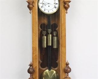A 19th century Vienna Regulator wall clock by F. Lichtblau, Rudolfsheim.  8-day weight driven movement with quarter hour Grand Sonnerie strike with a two-part porcelain dial, Roman numerals and molded Brass bezel.  Walnut case with a shaped crest and two carved finials over an arched door with carved detail, a shaped back panel and a shaped lower drop with Burl Walnut panel and carved finials.  Older cleaned finish with minor wear, shrinkage crack in door, running when cataloged.  56" high overall.  ESTIMATE $1,000-1,500