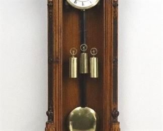 A 19th century Vienna Regulator wall clock by J. Weber, Wien.  8-day weight driven movement with quarter hour Grand Sonnerie strike with a two-part porcelain dial, Roman numerals and molded Brass bezel.  Transitional style Walnut case with a shaped crest and two finials over an arched door, canted corners with carved Bellflower detail and carved panels with a shaped lower drop with turned finials.  Older cleaned finish with minor wear, shrinkage crack in door, hairlines in dial, running when cataloged.  54" high overall.  ESTIMATE $800-1,200