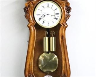 A 19th century Vienna Regulator wall clock by D. Gunsler, Wien.  8-day weight driven movement with a two-part porcelain dial, Roman numerals and molded Brass bezel.  Serpentine Walnut case with a shaped crest with deeply carved floral decoration over a shaped door with floral carved corners and a shaped lower drop with carved finials.  Older finish with minor wear, shrinkage cracks in door with plexi-glass glazing, running when cataloged.  38 1/2" high overall.  ESTIMATE $600-800