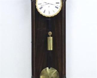 A 19th century Vienna Regulator wall clock.  8-day weight driven movement with a flat porcelain dial, Roman numerals and Bronze piecrust bezel.  Mixed wood case with original grain painted finish and composition decoration including the crown, door corners and lower finial with a shaped lower drop.  Original finish with minor wear, running when cataloged.  43 1/2" high overall.  ESTIMATE $600-800