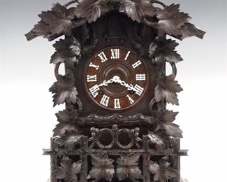An early 20th century German Black Forest mantle cuckoo shelf clock by Gordian Hettich & Sohn, Furtwangen.  Good quality brass 8-day time and strike movement with Cuckoo and Gong strike, wooden dial with applied Roman numerals.  Walnut case with grape leaf crest and dial surround, and lower grape arbor design on a molded base.  Older dark finish older repairs, replaced pendulum, running when cataloged. 20 1/4" high. ESTIMATE $800-1,200