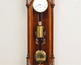 A very good quality late 20th century Inlaid Vienna Regulator wall clock by Lonsdale & Snelling, England.  60-day weight driven time only movement with a flat porcelain dial, Roman numerals and gilded engine turned bezel, marked "Lonsdale & Snelling, 005", all parts numbered #005.   Biedermeier style Rosewood case with Brass and Pewter marquetry inlay features a carved crest above an arched molded crown with inlaid frieze, an arched door with chamfered corners and fluted columns with carved capitols inlaid back panel and shaped inlaid drop and lower finial.  Original finish in excellent condition, one cracked side glass, running when cataloged.  57 3/4" high overall.  ESTIMATE $3,000-5,000