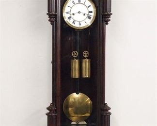 A 19th century Vienna Regulator wall clock.  8-day weight driven time and strike movement with a two-part porcelain dial with Roman numerals and seconds bit with a molded Brass bezel.  Figured Walnut Transitional case with Ebonized detail, shaped molded crest with turned detail over shaped door with turned pilasters, lower fluted turnings and turned finials, shaped drop with finial.  Old finish with minor wear, running when cataloged.  47 1/2" high overall.  ESTIMATE $400-600