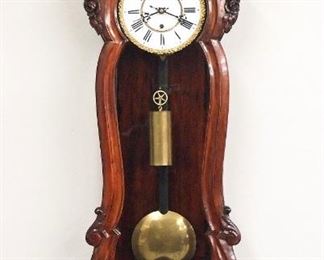 A 19th century Vienna Regulator wall clock.  30-day weight driven time only movement with two-part porcelain dial, Roman numerals and Bronze Piecrust bezel.  Mahogany Serpentine case with carved floral crest over a shaped door with floral carvings, shaped drop and carved finial.  Refinished with some wear, nailed repairs to lower case, one damaged side glass, dial hairlines, running when cataloged.  47 1/2" high overall.  ESTIMATE $800-1,200