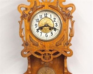 A turn of the century Gustav Becker freischwinger wall clock.  8-day spring driven time and strike movement with porcelain chapter ring, Arabic numerals, embossed Brass dial center and matching gridiron pendulum, serial #1526517.  Jugendstil Period carved Oak case with pierced molded crest on a carved door with circular dial glass and Brass bezel over a shaped lower drop.  Refinished with some wear, several chips and painted touchups to chapter ring, running when cataloged.  32" high.  ESTIMATE $200-300
