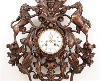 A 19th century carved French gallery clock by Samuel Marti et Cie.  8-day time and strike movement with visible escapement, two part porcelain dial and Roman numerals.  Carved Walnut case with Man's head, flanked by Rampant Lion and Horse figures, open scrollwork with floral and foliate design with lower bird figures.  Older finish with minor wear, minor damage, supports added to rear of case, running when cataloged.  21 3/4" high overall.  ESTIMATE $600-800