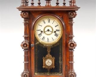 A late 19th century E. N. Welch "Gerster V P" model shelf clock.  8-day time and strike movement with bell, painted metal dial with Roman numerals.  Rosewood case with gallery crest over and arched door with stenciled glass flanked by turned columns on a molded base.  Older finish with slight wear, replaced backboard, running when cataloged.  18 1/2" high.  ESTIMATE $400-600