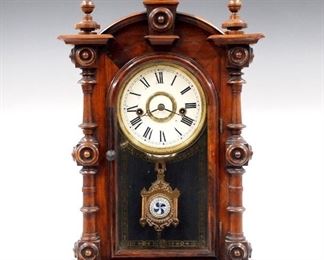 A late 19th century E. N. Welch "Patti V P" model shelf clock.  8-day time and strike movement with bell, painted metal dial with Roman numerals.  Rosewood case with an arched crest and turned finials over and arched door with stenciled glass flanked by turned columns on a molded base.  Paper label on back 90% intact.  Older refinish with slight wear, restored paint on dial, running when cataloged.  19" high.  ESTIMATE $400-600