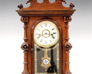 A late 19th century E. N. Welch "Cary V P" model shelf clock.  8-day time and strike movement with bell, painted metal dial with Roman numerals.  Rosewood case with a scrolled crest over and arched door with stenciled glass flanked by turned columns on a molded base.  Paper label on back 70% intact.  Older finish with slight wear, restored paint on dial, pin added to top finial, running when cataloged.  20 1/2" high.  ESTIMATE $400-600