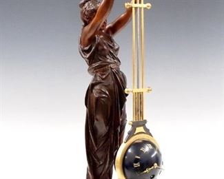 A late 19th century French figural upside-down swing clock by André Romain Guilmet, Paris.  8-day time only movement in a spherical case hangs from a bi-metallic gilded bronze gridiron pendulum, dark Blue sphere with Gold Roman numerals.  Patinated Spelter figure of a classical draped woman suspends the pendulum within a scrolled Brass frame, supported by a Spelter base with Slate insert and paw feet.  Case refinished, dial lacks two numerals, running when cataloged.  26 3/4" high overall.  ESTIMATE $2,000-3,000
