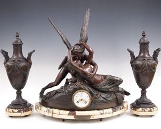 A turn of the century French three piece clock set entitled "Amour et Psyche (Cupid and Psyche) after the original by Canova.  8-day time and strike movement with hand painted porcelain dial and Arabic numerals marked "J. Leiri, Perigueux".  Spelter figural case with original two color patina and molded marble base with two covered urns on circular marble bases.  Original finish with minor wear, replaced minute hand, running when cataloged.  Clock 20 1/2" high, vases 18" high.  ESTIMATE $1,000-1,500