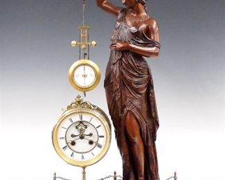 A late 19th century French figural mystery clock by Samuel Marti et Cie, Paris.  8-day spring driven time and strike movement with visible escapement, open pendulum and two-part porcelain dial with Roman numerals.  Cast Spelter Classical draped female figure suspends the gilded gridiron pendulum and stands on a Rouge marble base.  Assembled parts, figure refinished, dial hairlines, not running when cataloged.  26 3/4" high overall.  ESTIMATE $600-800