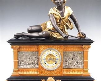 A late 19th century Ansonia "Columbia" model figural clock.  8-day time and strike movement with visible escapement and embossed Brass dial with porcelain markers and Roman numerals.  Japanned Iron case with patinated  Spelter decoration including a figure of a shepherd boy, bas relief panels with battle scenes within Neoclassical frames with columns at the corners all supported by scrolled feet.  Shepard boy has been refinished with additional older restoration, minor wear, running when cataloged.  25 1/2" high.  ESTIMATE $1,000-1,500
