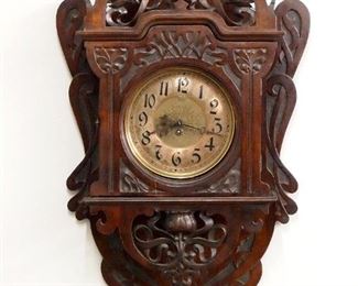 An unusual late 19th century Sylvester Jugendstil wall clock.  1 year spring driven time only movement with balance wheel escapement, etched metal dial with Arabic numerals, marked "Jahresuhr Sylvester, Patentirt in allen, Culterstaaten" serial #162.  Jugendstil Period carved Walnut case with pierced floral crest over dial door with circular glass and carved floral detail, pierced apron and shaped carved drop.  Original finish with some wear, shrinkage crack in door frame, running when cataloged.  34" high overall.  ESTIMATE $1,000-1,500