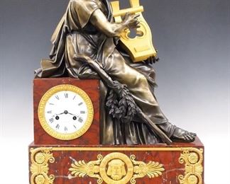 A 19th century French Empire Period Bronze and Marble mantle clock by Honoré Pons, Paris.  8-day time and strike movement with silk thread suspension and porcelain dial with Roman numerals and gilded Bronze bezel, marked with the retailer's name and address "B. Marchand, Richelieu No. 59".    Rouge marble case surmounted by a Bronze figure of the Greek Poet Homer seated holding a Gilded lyre on a stepped base with gilded Bronze appliques with central mask and foliate detail and moldings on flattened bun feet.  Some surface wear, several older glued repairs with the marble, running momentarily when cataloged.  30 3/4" high overall.  ESTIMATE $2,000-3,000