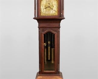 A 1920's Waltham Chiming Grandfather clock.   8-day weight driven three train movement with striking on five tubular chimes, arched Brass dial with painted moon phases and engraved hemispheres, a Silvered chapter ring with Arabic numerals and subsidiary dials for seconds, Strike/Silent, Chime/Silent, engraved filigreed spandrels and dial center, damascened plates.  Mahogany Chippendale style case with hand carved decoration features an arched molded pediment above a shaped dial door flanked by turned fluted columns over waist door with beveled glass panel flanked by fluted quarter columns on a paneled base with carved paw feet.  Original dark finish with some wear, running when cataloged.  96 1/4" high.  ESTIMATE $1,500-2,500