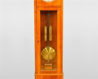 A late 19th century Cherry Biedermeier tall clock by Lorenz Furtwangler & Sohn.   8-day time and strike movement with dead Beat escapement, Silvered dial and Arabic numerals and subsidiary seconds, backplate marked with "LFS" trademark and serial #918, bi-metalic compensating pendulum.  Cherry Biedermeier style case, upper dial door with circular glass and waist door with beveled class, over a paneled base with simple scalloped plinth.  Older finish with fading, minor exterior veneer damage, some veneer loss inside the waist base, running when cataloged.  78 1/2" high.  ESTIMATE $1,000-1,500