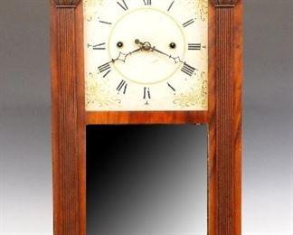 A 19th century Merriman, Birge & Co. Ives Patent shelf clock.  30-hour weight driven wooden time and strike movement with painted wooden dial with Roman numerals.  Mahogany case with a scrolled crest and Brass finials over a door with clear dial glass, mirrored center and reverse painted lower flanked by flat reeded pilasters with carved capitols, on a flat base.  Paper label 80% intact.  Older refinishing with minor wear, minor dial wear, restored lower glass, running when cataloged.  37 1/4" high.  ESTIMATE $400-600