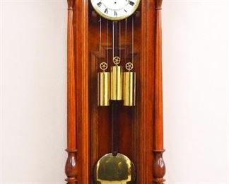 A 19th century Vienna Regulator wall clock.  30-day weight driven movement with quarter hour Grand Sonnerie strike and a two-part porcelain dial with Roman numerals and a molded Brass bezel.  Transitional style Walnut case features a molded arched crown with shaped crest and finials over a single arched door with turned pilasters, shaped drop with turned finials.  Refinished with slight wear, replaced crest and finials, running when cataloged.  65 1/2" high overall.  ESTIMATE $2,000-4,000