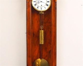A 19th century Vienna Regulator wall clock.  90-day weight driven time only movement with a two-part porcelain dial with Roman numerals and molded Brass bezel.  Walnut case with added Gilded Bronze scrollwork at top and bottom features an arched crown and door with slender turned pilasters, molded bottom with cast scroll.  Older finish with some wear, dial hairlines, lacks original crown and drop, not running when cataloged.  56 1/2" high overall.  ESTIMATE $800-1,200