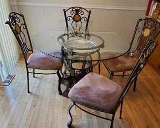 Round glass table with four upholstered chairs