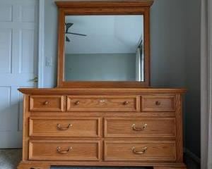 Mirrored Wooden Dresser. This item matches the previous lot. There are some light scratches that can be seen in the photos. Measures 63” wide, 18” deep and 74” high.