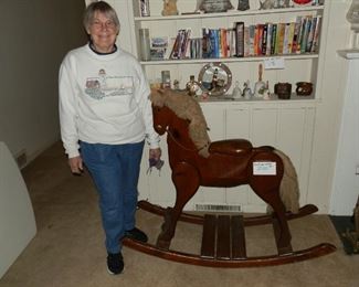 Margie standing next to the large, custom made wood rocking horse! 