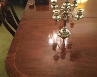 SHOWING THE AMASSING DINING TABLE IT IS MAHOGANY WITH CROSS BANDING AND STRING INALY, IT HAS TWO 24 INCH LEAVES AND WILL SEAT 10 TO 12 PERSONS COMFORTABLY