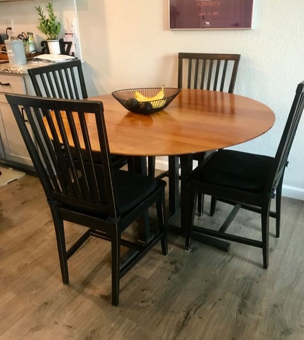 Great round table with 4 black slat-back chairs