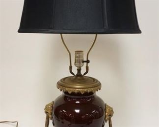 1163 ASIAN OXBLOOD TABLE LAMP W/BRASS FOO DOGS & GROTESQUE FACE ON BASE, APPROXIMATELY 29 IN HIGH