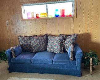 Sofa with thro pillows, colored glass, faux decore plants