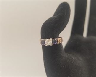 AVAILABLE FOR PRESALE. Rose gold stamped “solid Gold.” Center diamond approx. 0.38 ct. Flanked by 2 round sapphires. White & gold settings.