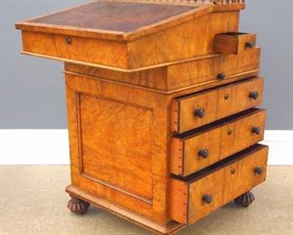 A late 19th century English Victorian Period Davenport desk. Burr Walnut construction with a galleried sliding upper section with inset leather slope, with four interior drawers and a small pen and ink drawer on the right side, lower section with pull out slides, over three dovetailed drawers on one side and three faux drawers opposite, on carved bun feet. Old faded finish with wear and minor damage. 20 x 22 x 30 1/2" high overall. ESTIMATE $600-800