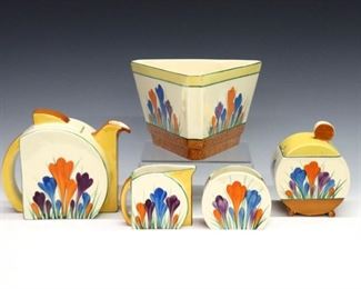 Five pieces of early 20th century Clarice Cliff "Crocus" pattern Bizarre Ware. Includes a triangular bowl, teapot, creamer, sugar and jam pot. Painted marks. Some wear to surface and decoration, chip to corner and inner rim of waste bowl. Up to 4 3/4" high. ESTIMATE $300-400
